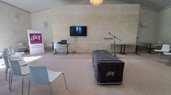 Sala del commiato A.Se.F. con sedute, leggio e supporto per il feretro.