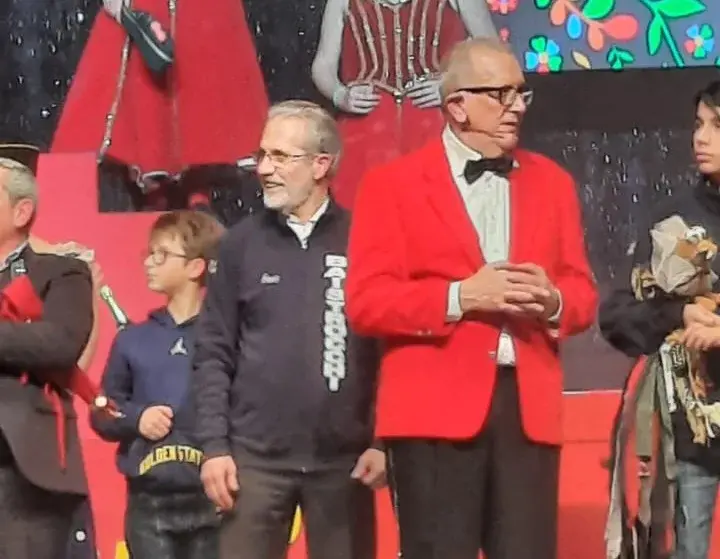Ospiti sul palco accanto a un componente della Baistrocchi in giacca rossa.
