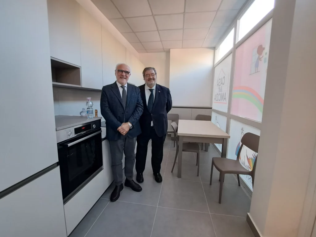 Partecipanti all’inaugurazione accanto agli elettrodomestici della nuova cucina della Casa dell’Amicizia.