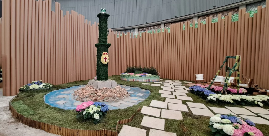 Vista dello stand A.Se.F. a Euroflora con la Lanterna verde, il prato e le aiuole fiorite.