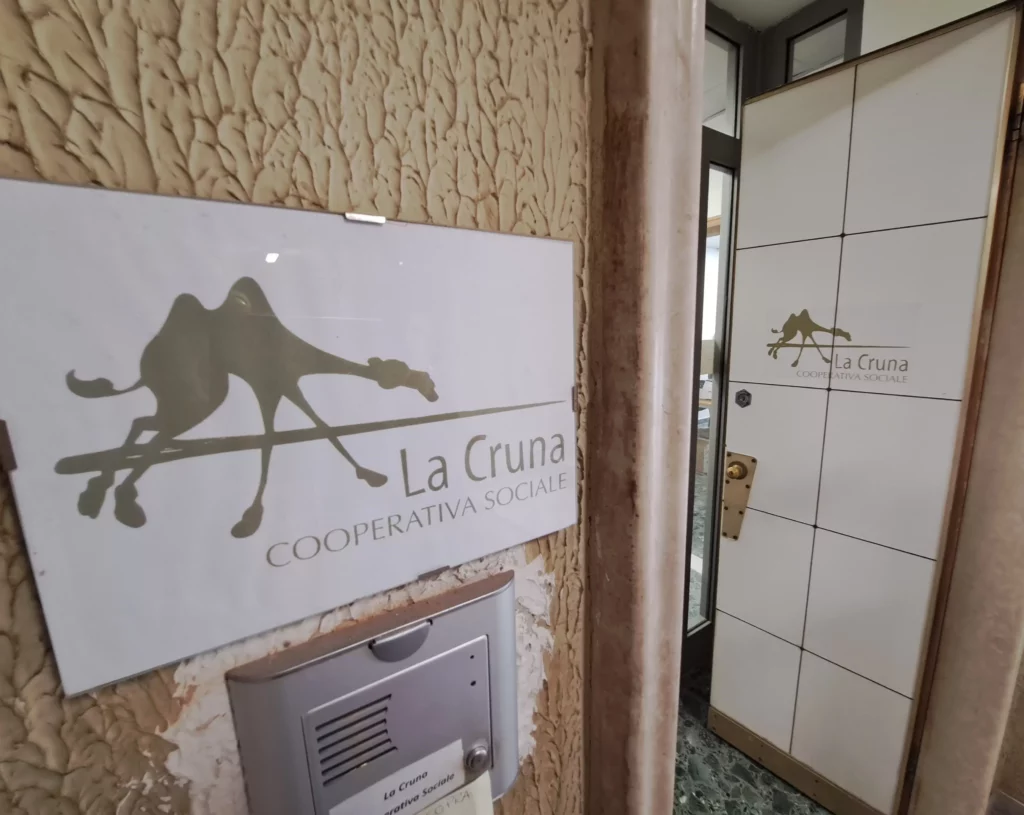 Ingresso della cooperativa sociale La Cruna, con targa e citofono.
