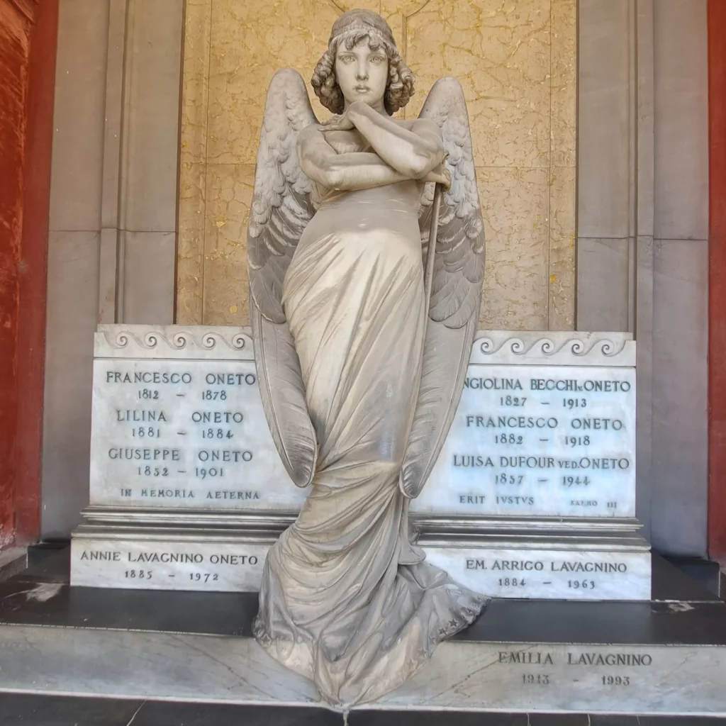 Statua di un angelo con le braccia incrociate nel cimitero di Staglieno.