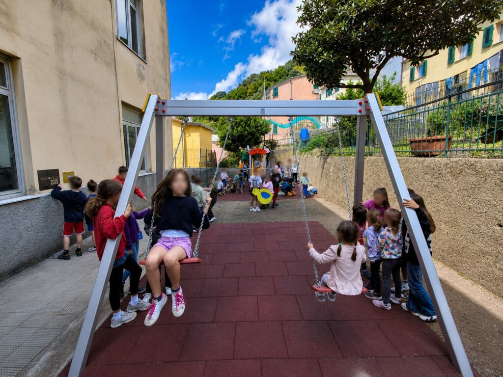 Bambini sulle altalene della nuova area giochi della scuola Canepa di Crevari.