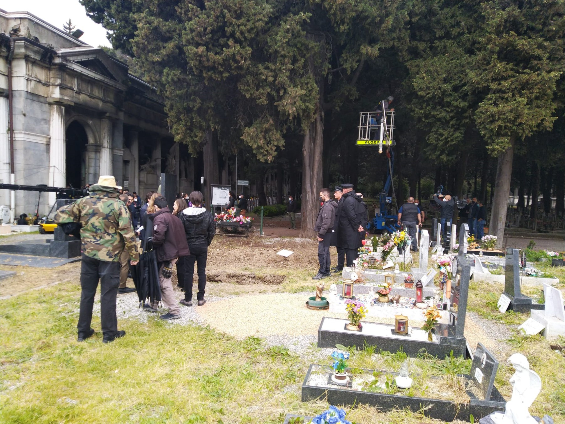 Troupe e attrezzature di ripresa tra le tombe del cimitero. 