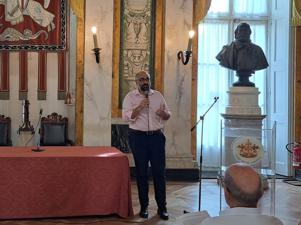Un relatore parla al microfono durante la conferenza a Palazzo Tursi.