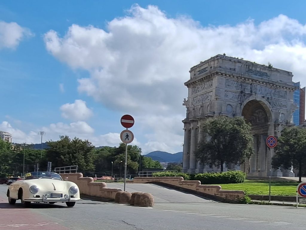 Auto sportiva d’epoca bianca passa davanti all’Arco della Vittoria di Genova.