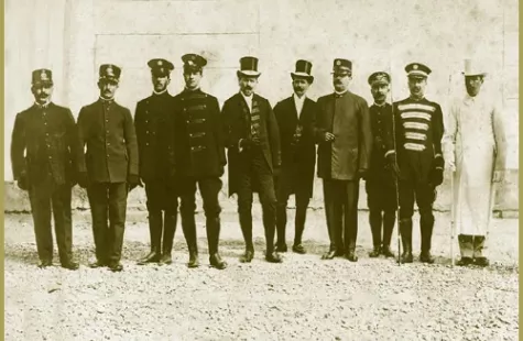 Fotografia d’epoca di un gruppo di uomini in uniforme e abiti formali.